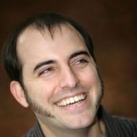 A man smiling in a black shirt in the San Francisco Bay Area.