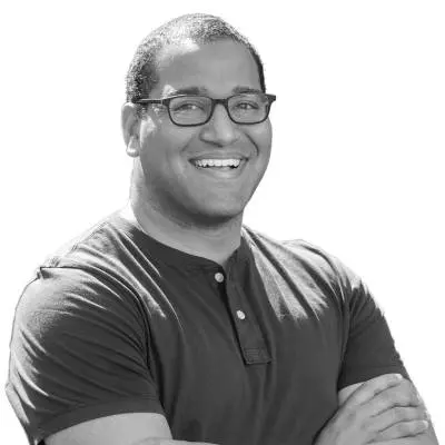 A black and white photo of a smiling man wearing glasses in the San Francisco Bay Area.