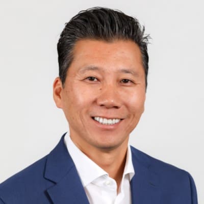 Asian man in a blue suit, specializing in San Francisco Bay Area technical recruiting services, smiling for the camera.