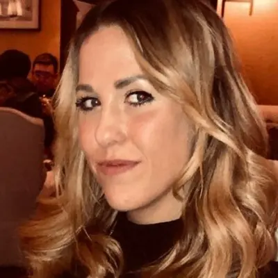 A woman with long wavy hair is posing for a picture.