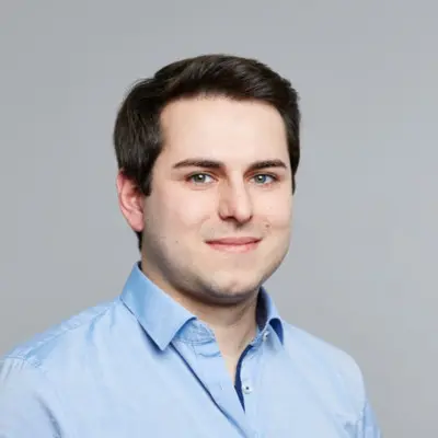 A man in a blue shirt is smiling for the camera.