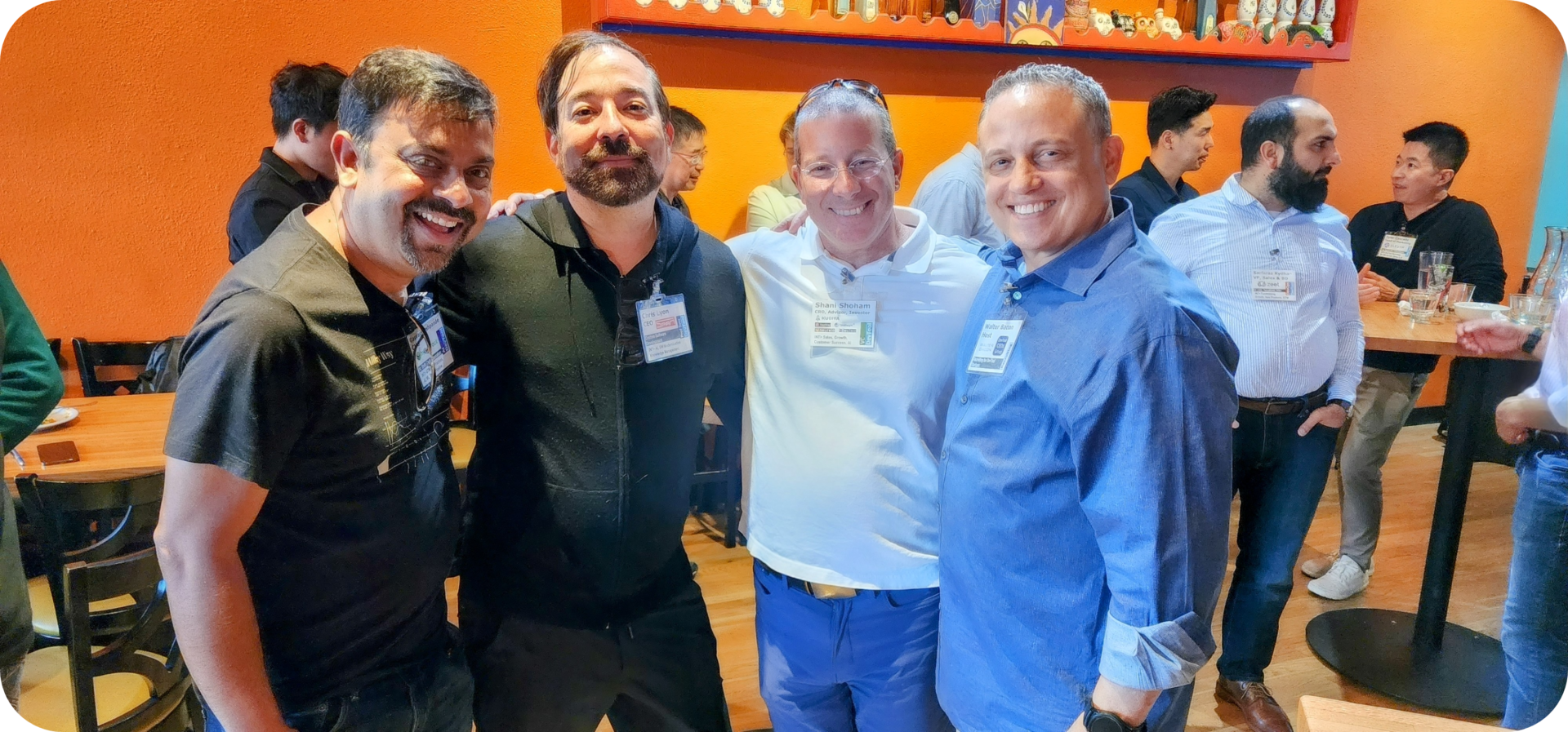 Four men smiling at a restaurant table.