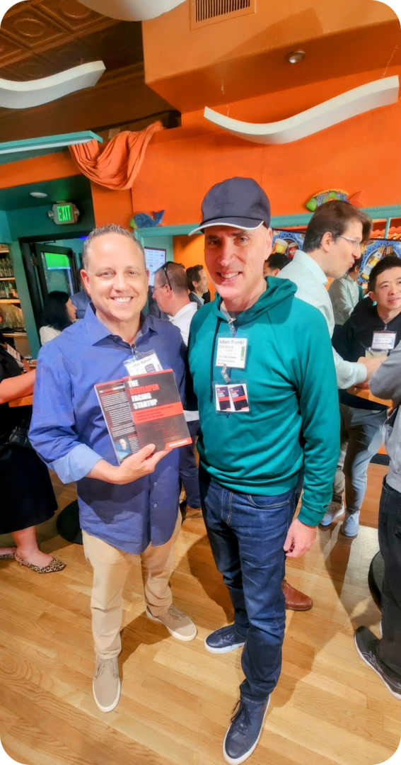 Two men holding a book titled "The Developer's Startup"