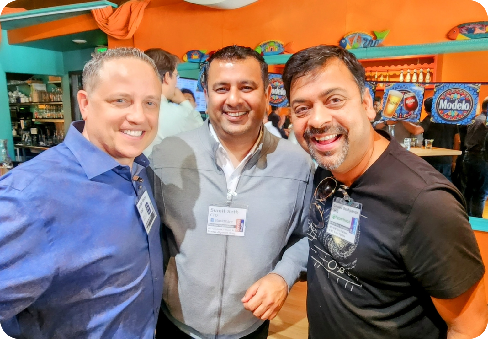 Three men smiling for a photo.